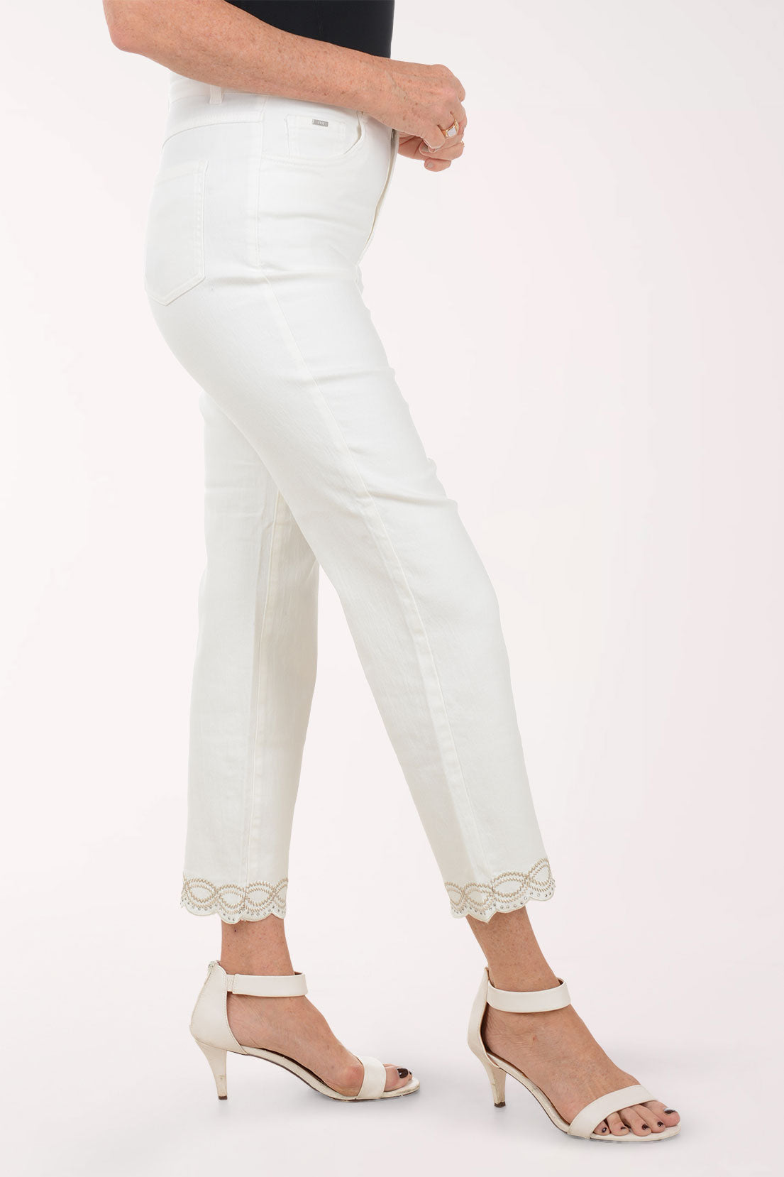 Person wearing white jeans with lace trim on a white background