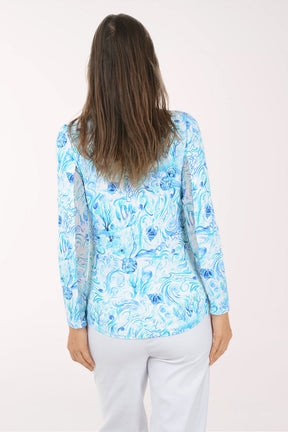 Woman wearing a blue floral long-sleeve shirt on a white background
