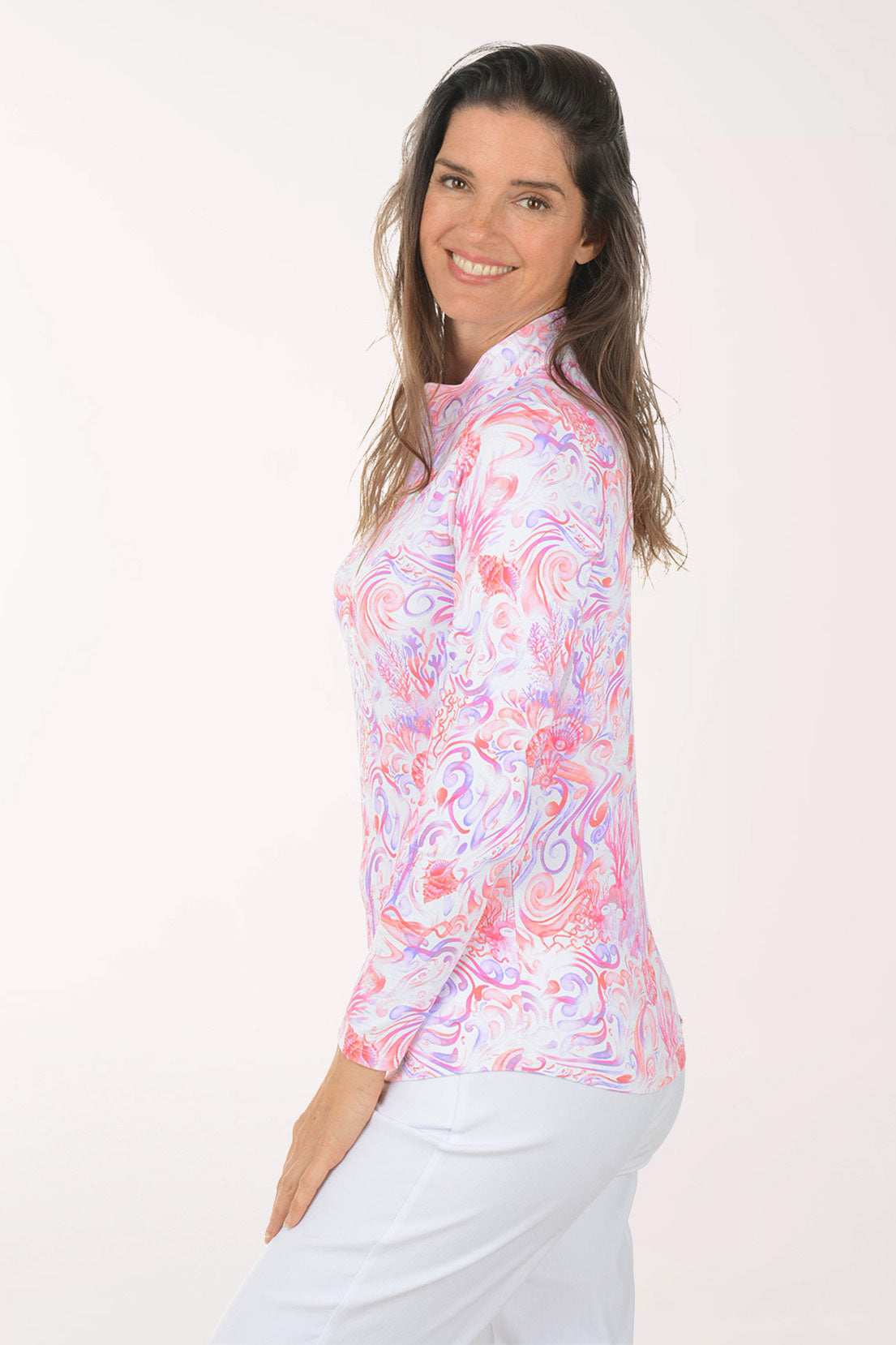 Woman wearing a colorful long-sleeve shirt with a white background