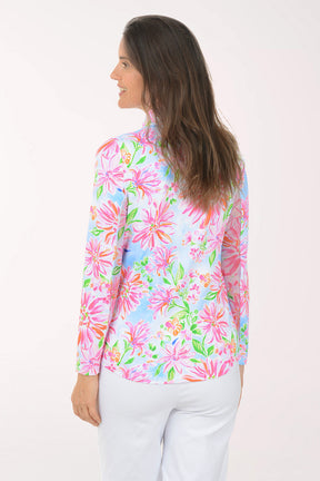 Woman wearing a colorful floral long-sleeve shirt on a white background