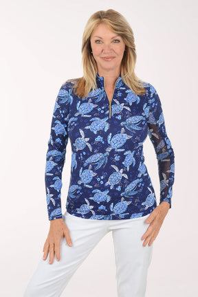 Woman wearing a blue turtle patterned shirt on a white background