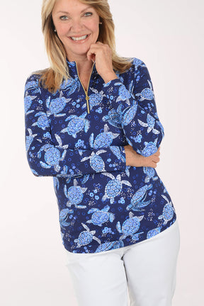 Woman wearing a blue turtle patterned shirt on a white background
