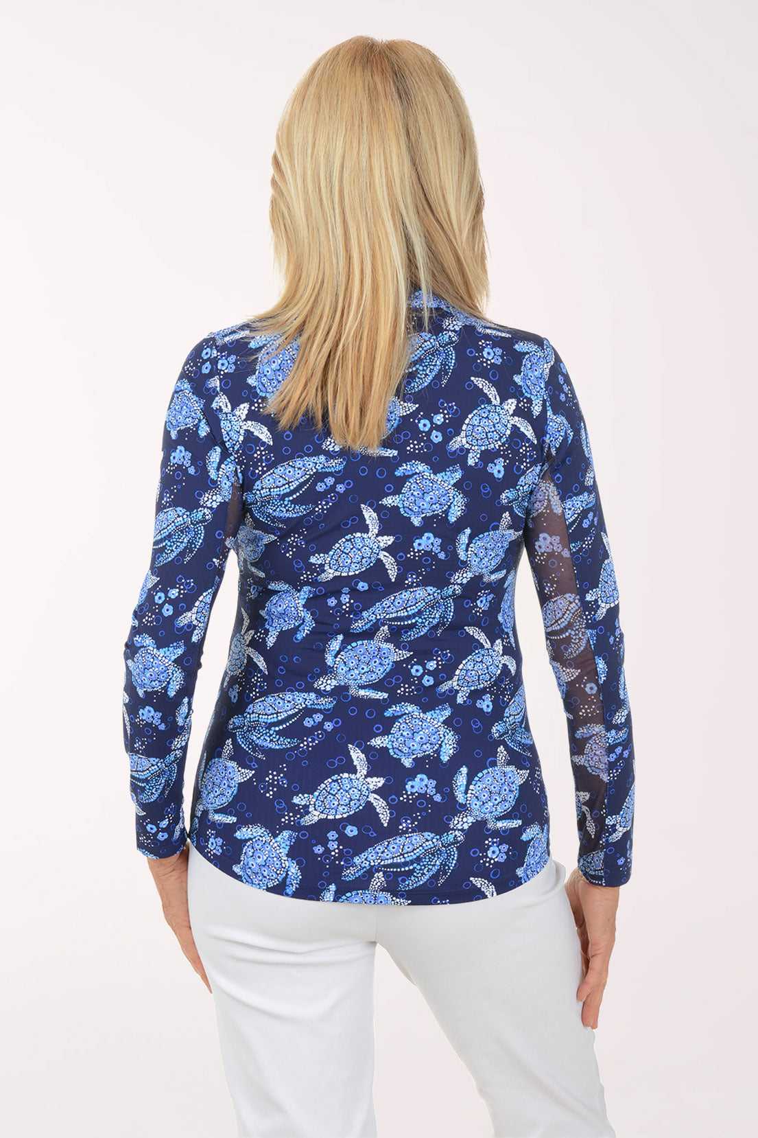 Woman wearing a blue turtle patterned shirt on a white background
