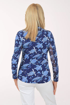 Woman wearing a blue turtle patterned shirt on a white background