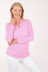Woman wearing a pink checkered shirt against a white background