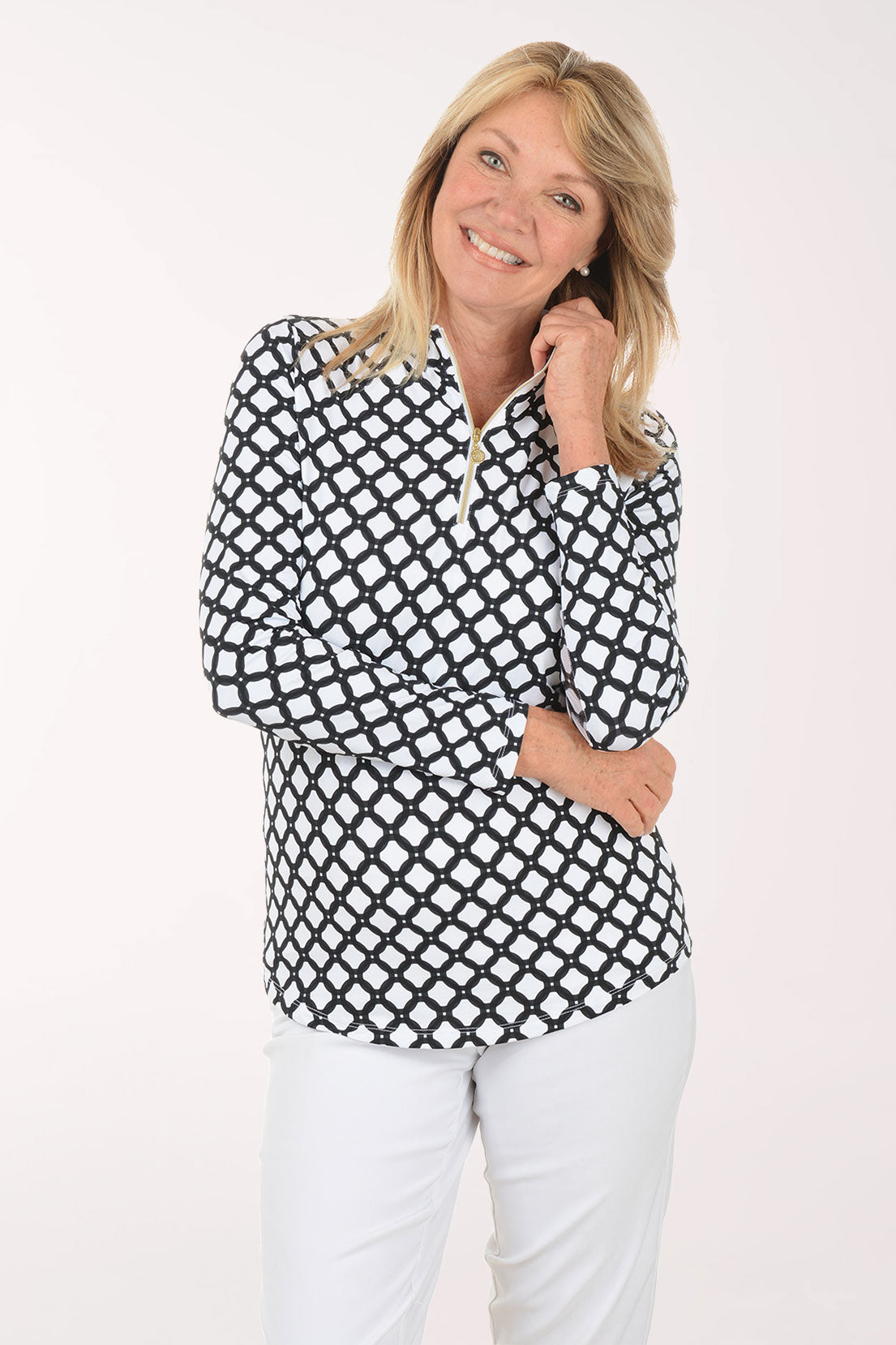 Woman wearing a black and white checkered blouse with white pants on a white background