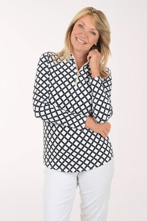 Woman wearing a black and white checkered blouse with white pants on a white background