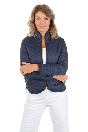 A woman wearing a navy quilted puffer jacket.