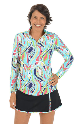 Woman wearing a colorful patterned long-sleeve shirt and black skirt on a white background.