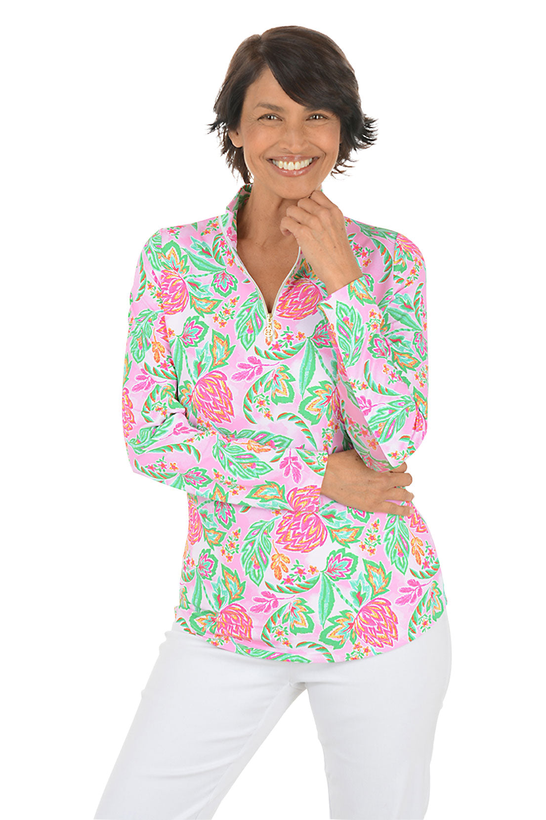 Woman wearing a colorful floral blouse with white pants on a white background