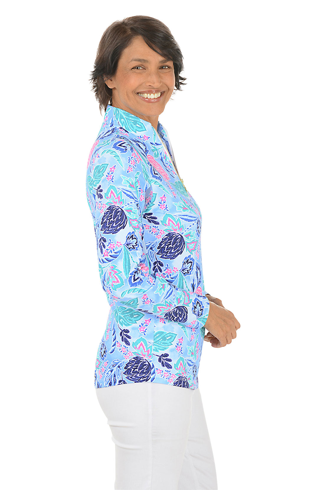 Woman wearing a colorful patterned shirt on a white background. Side shot.