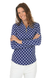 Woman wearing a blue patterned long-sleeve shirt with a white background.