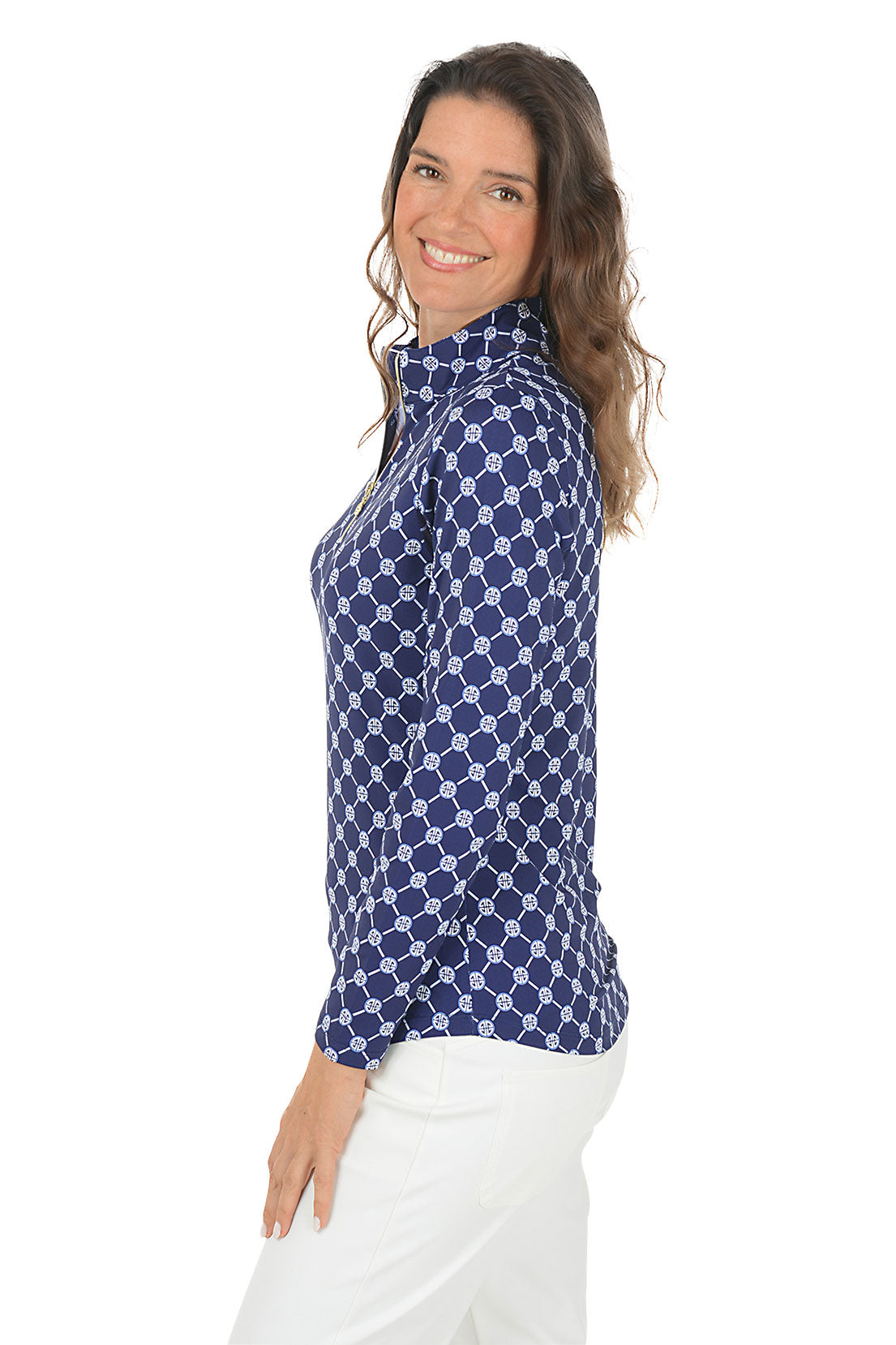 Woman wearing a blue patterned long-sleeve shirt with a white background. Side shot.