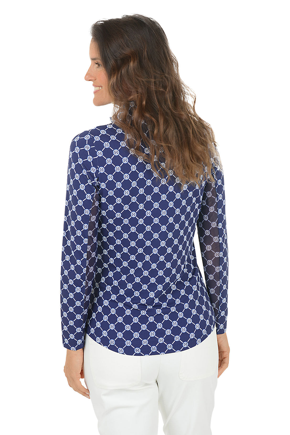 Woman wearing a blue patterned long-sleeve shirt with a white background. Back shot.