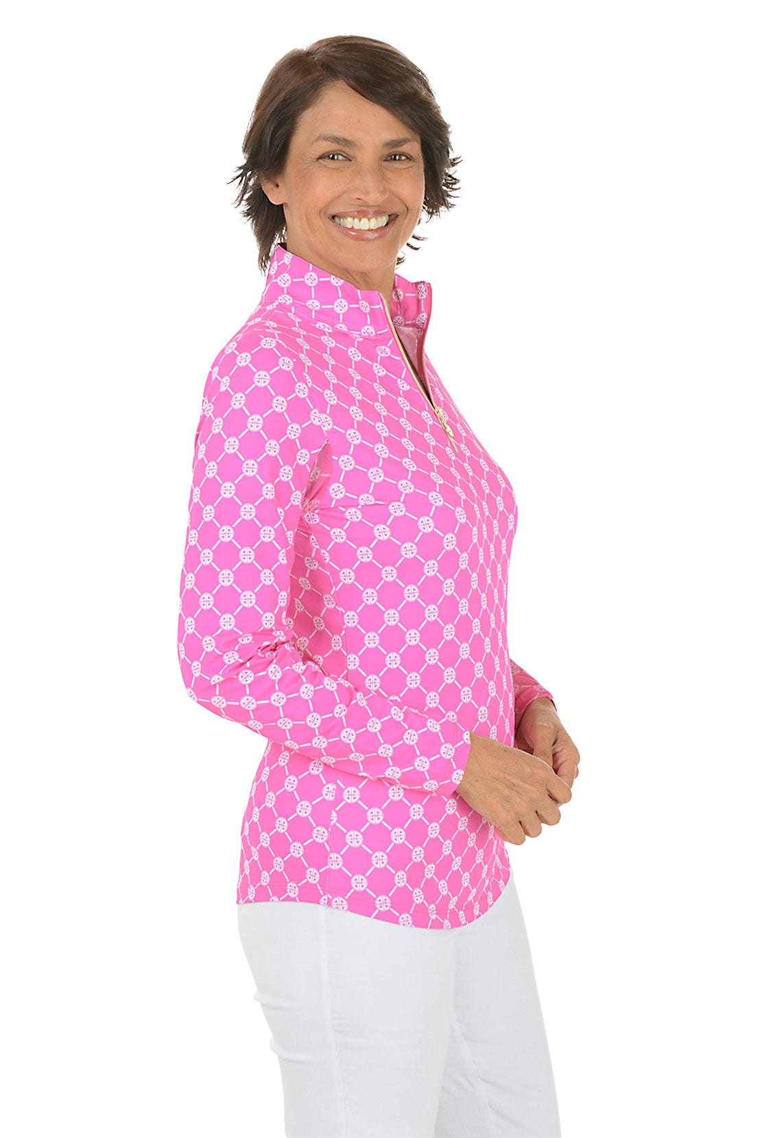 Woman wearing a pink geo-patterned long-sleeve shirt with a white background. Side shot.