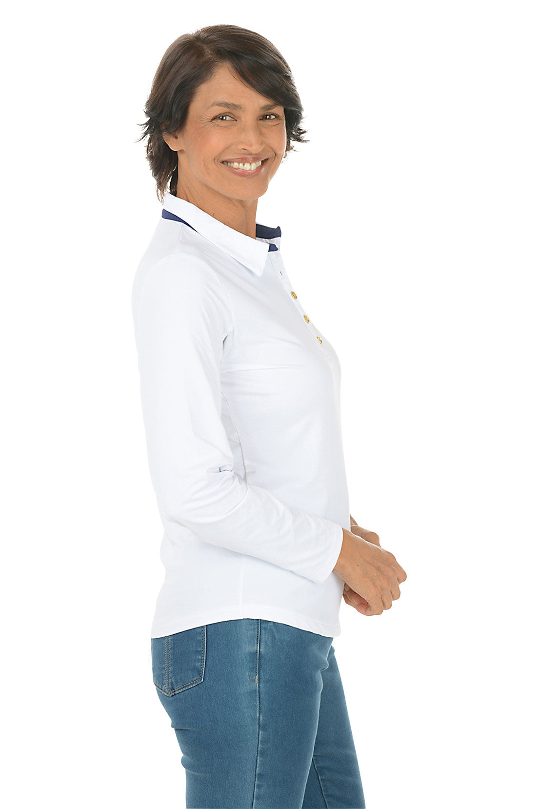 Woman wearing a white long-sleeve shirt and blue jeans on a white background. Side shot.