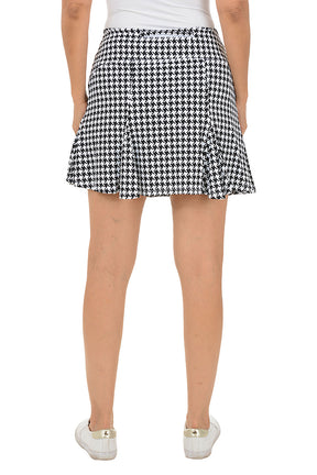 Person wearing a black and white checkered skirt on a white background. Back shot.