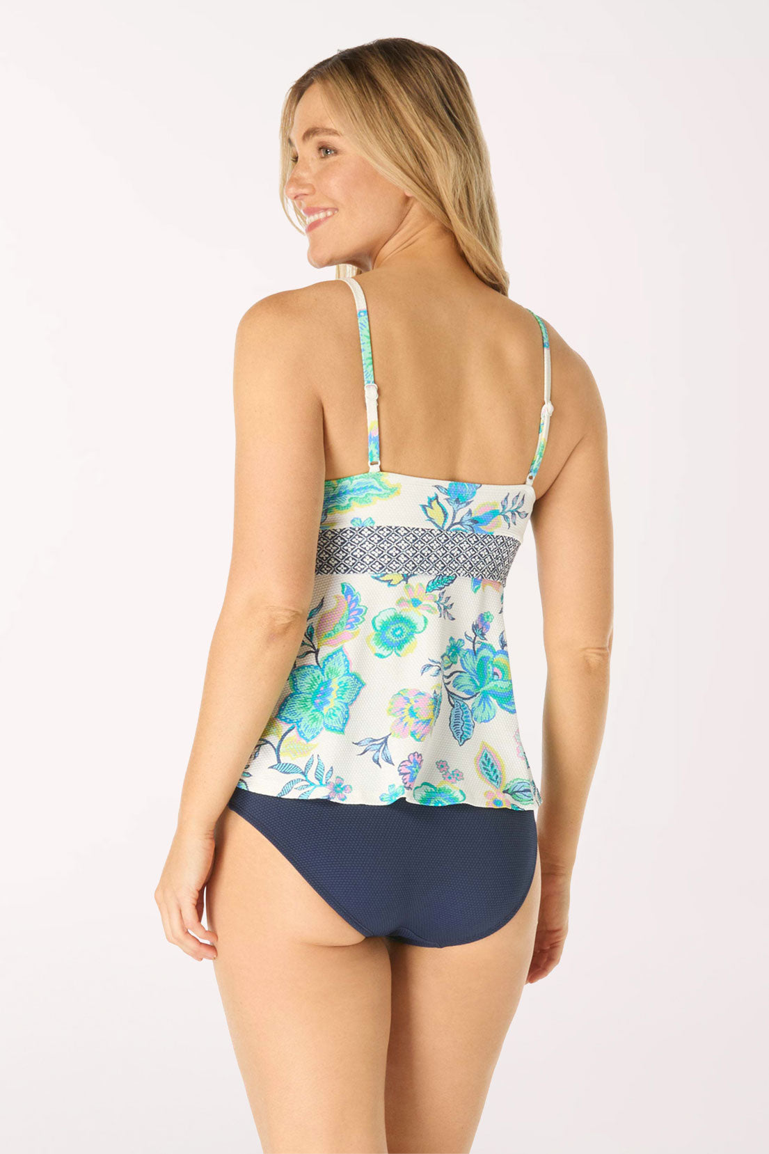 Woman wearing a floral tankini set on a white background