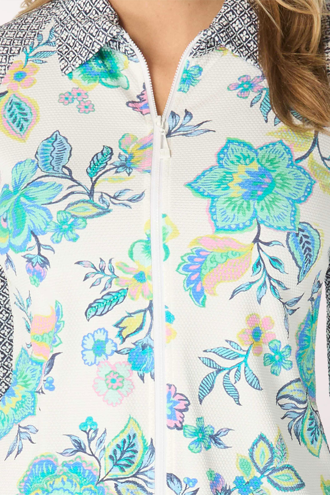 Woman wearing a floral rash guard with a patterned collar on a white background