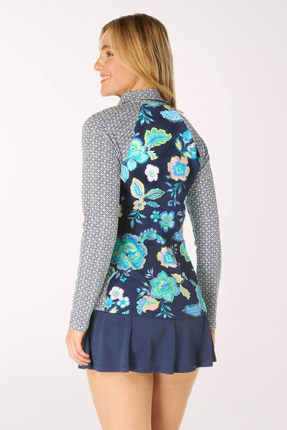 Woman wearing a navy floral rash guard with a patterned collar on a white background