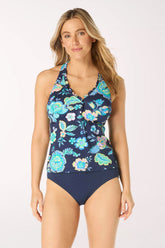 Woman wearing a navy floral tankini top swimsuit on a white background
