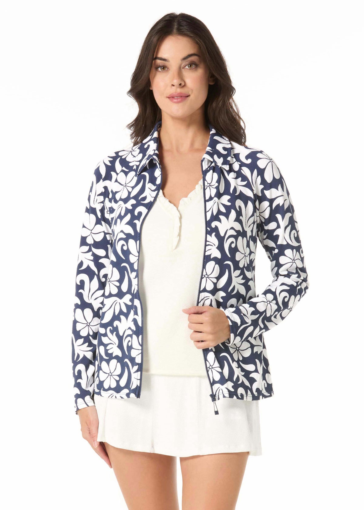 Woman wearing a navy floral jacket over a white top and skirt on a white background