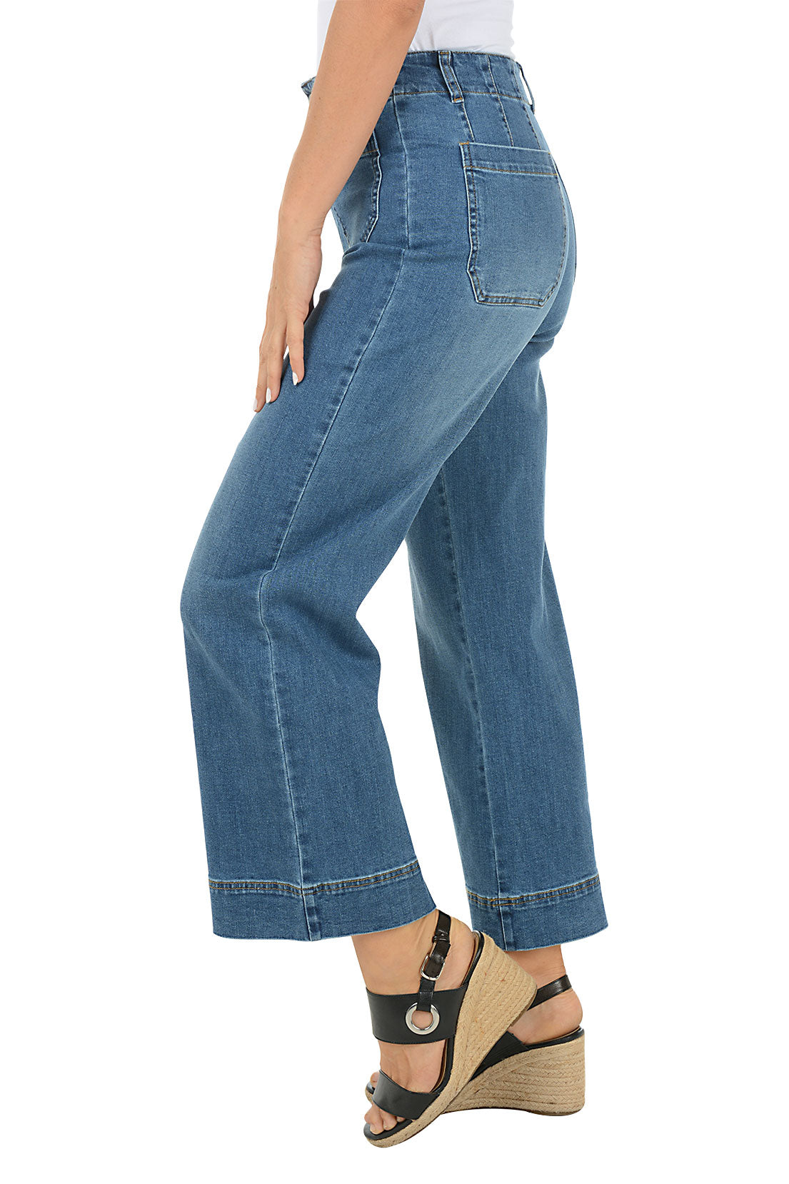 Person wearing blue jeans on a white background. Side shot.