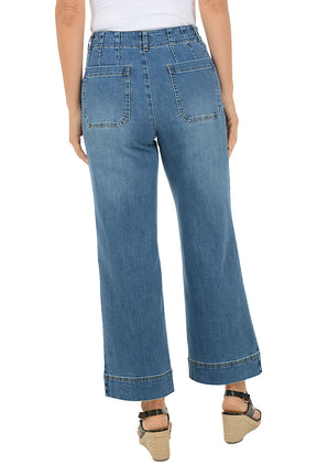 Person wearing blue jeans on a white background. Back shot.