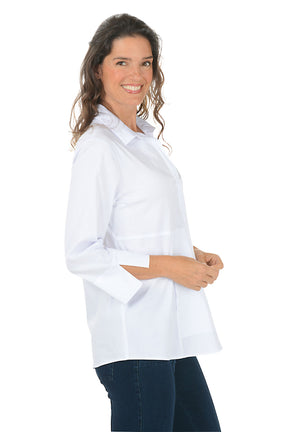 Woman wearing a white collared button down shirt and dark denim pants on a white background. Side shot.