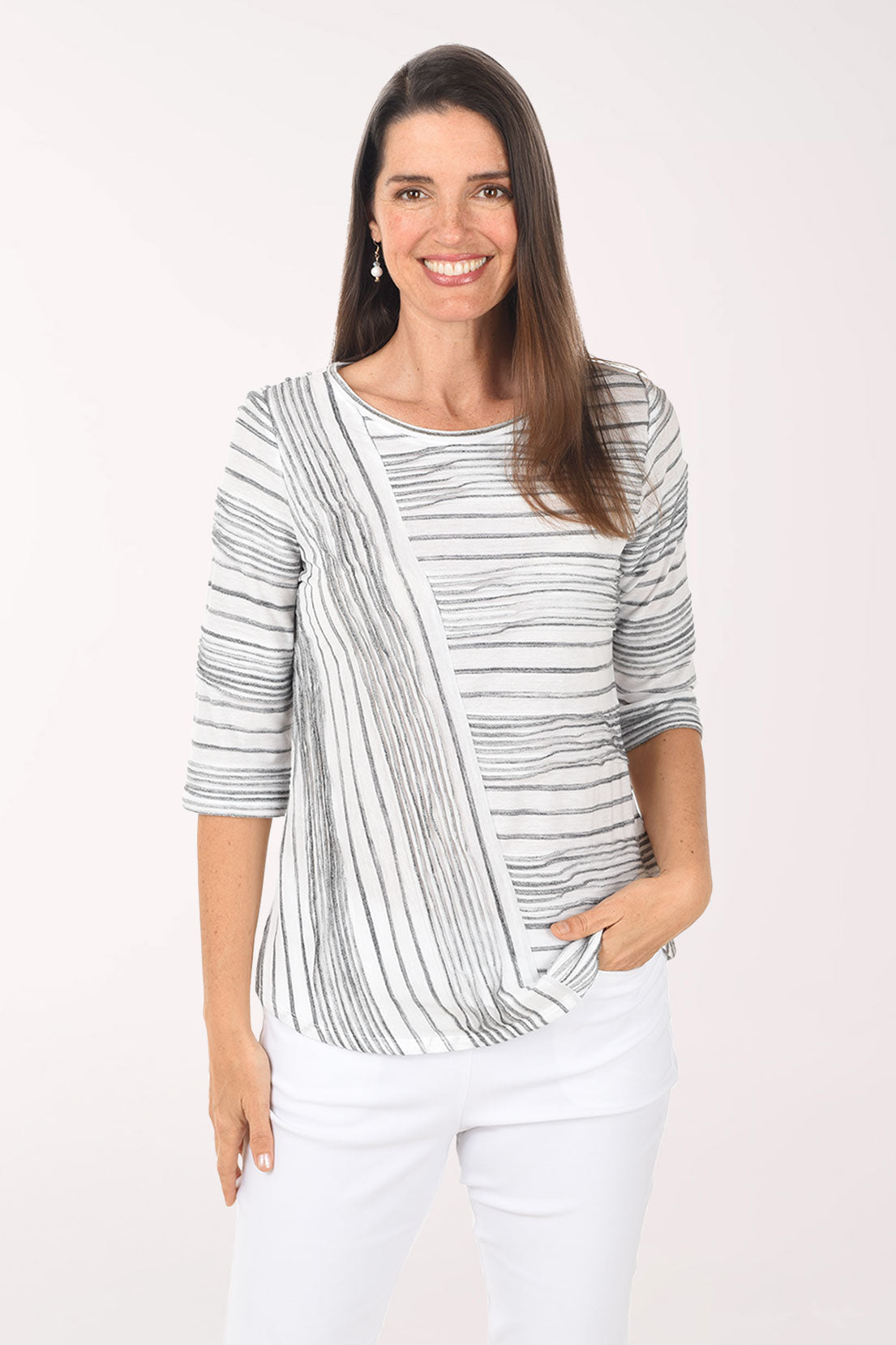 Woman wearing a striped sweater and white pants on a white background