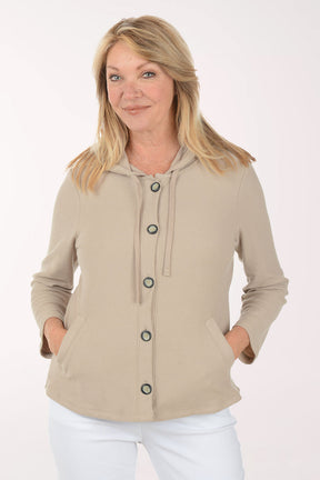 Woman wearing a beige jacket with black buttons on a white background
