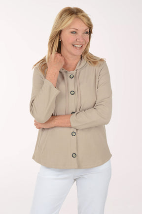 Woman wearing a beige jacket with black buttons on a white background