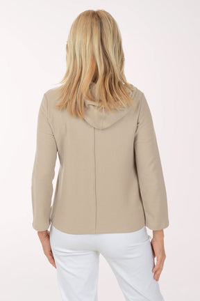 Woman wearing a beige jacket with black buttons on a white background