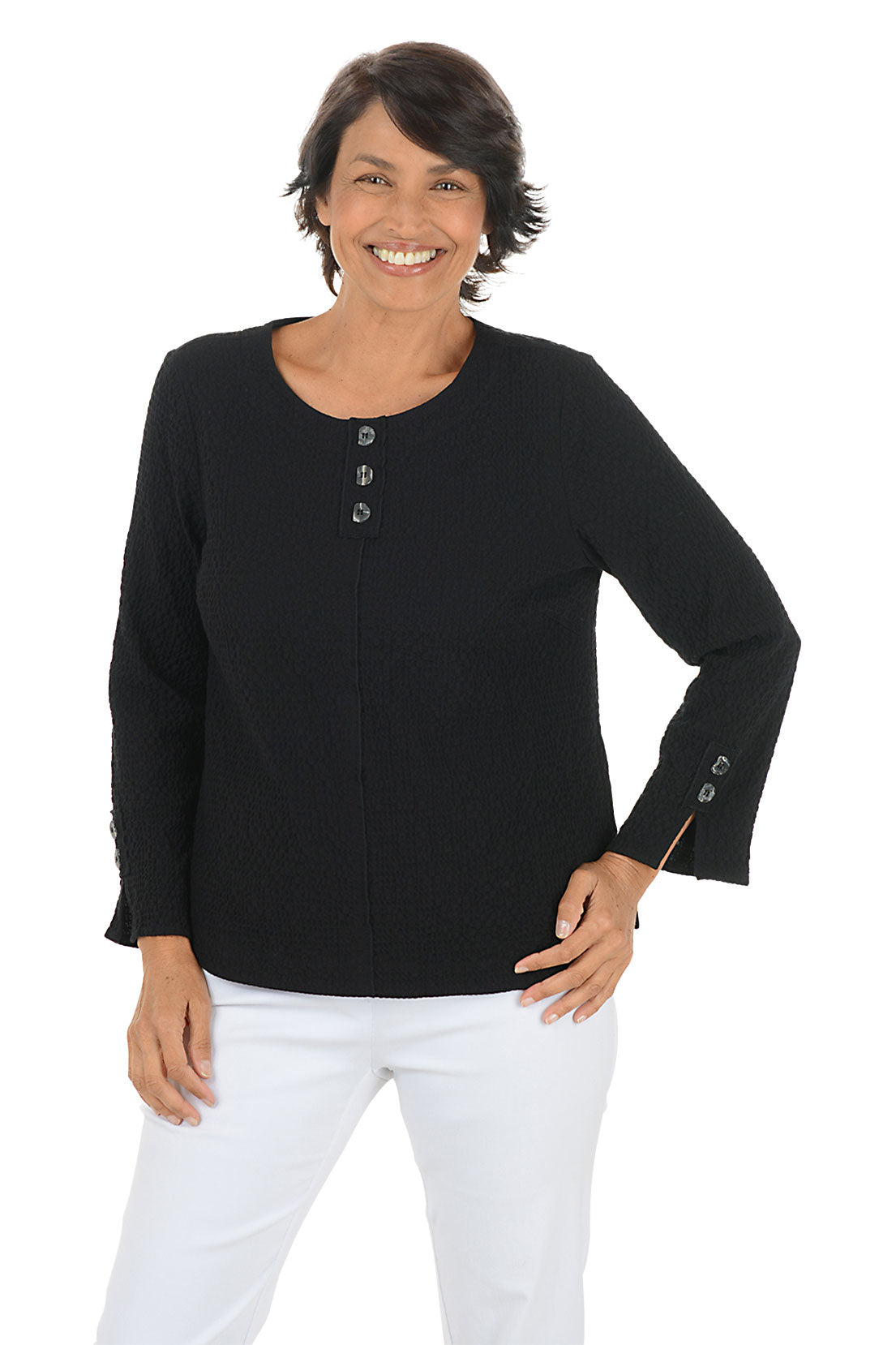 Woman wearing a black long-sleeve top with button details on a white background.
