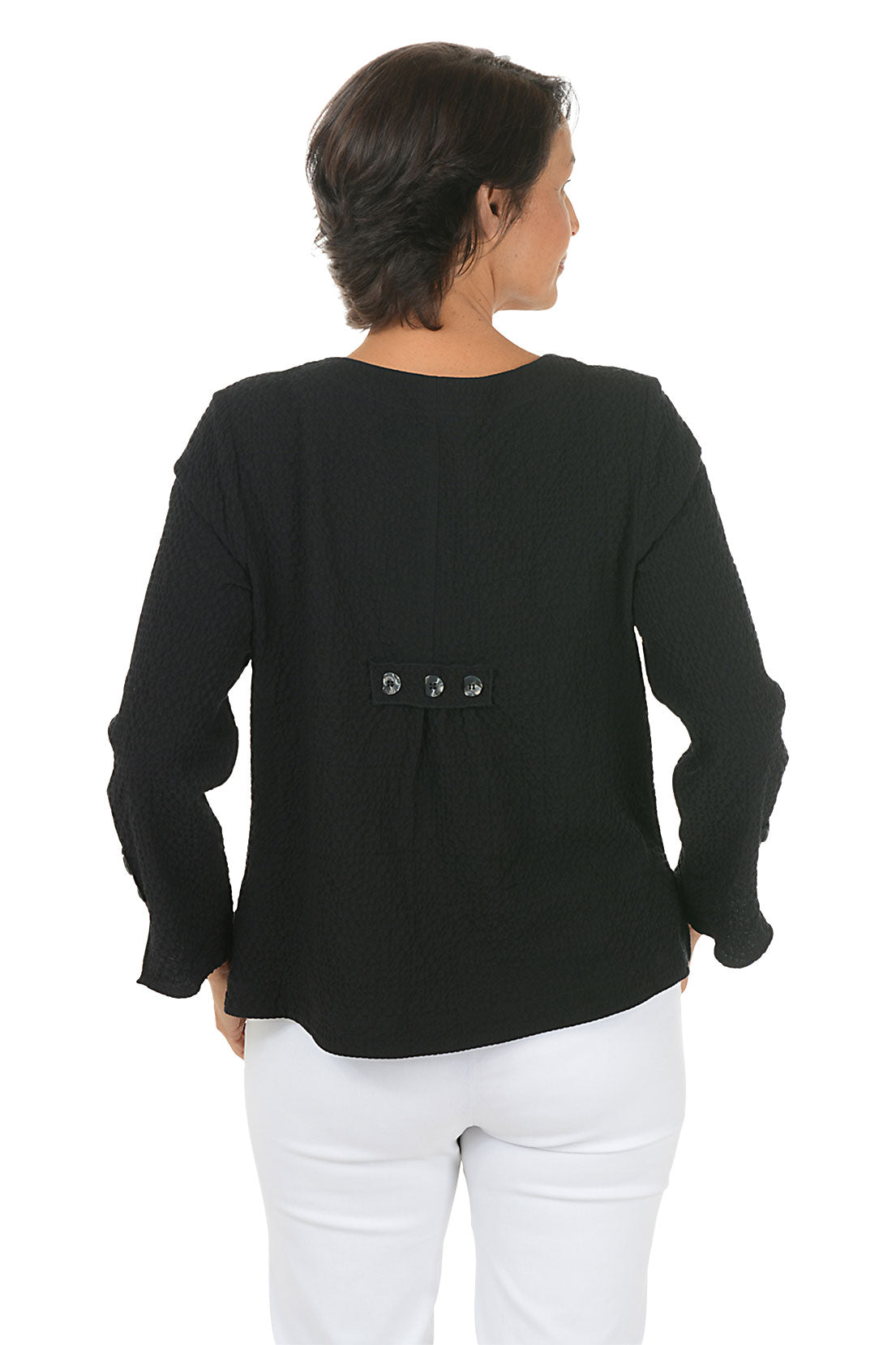 Woman wearing a black long-sleeve top with button details on a white background. Back shot.