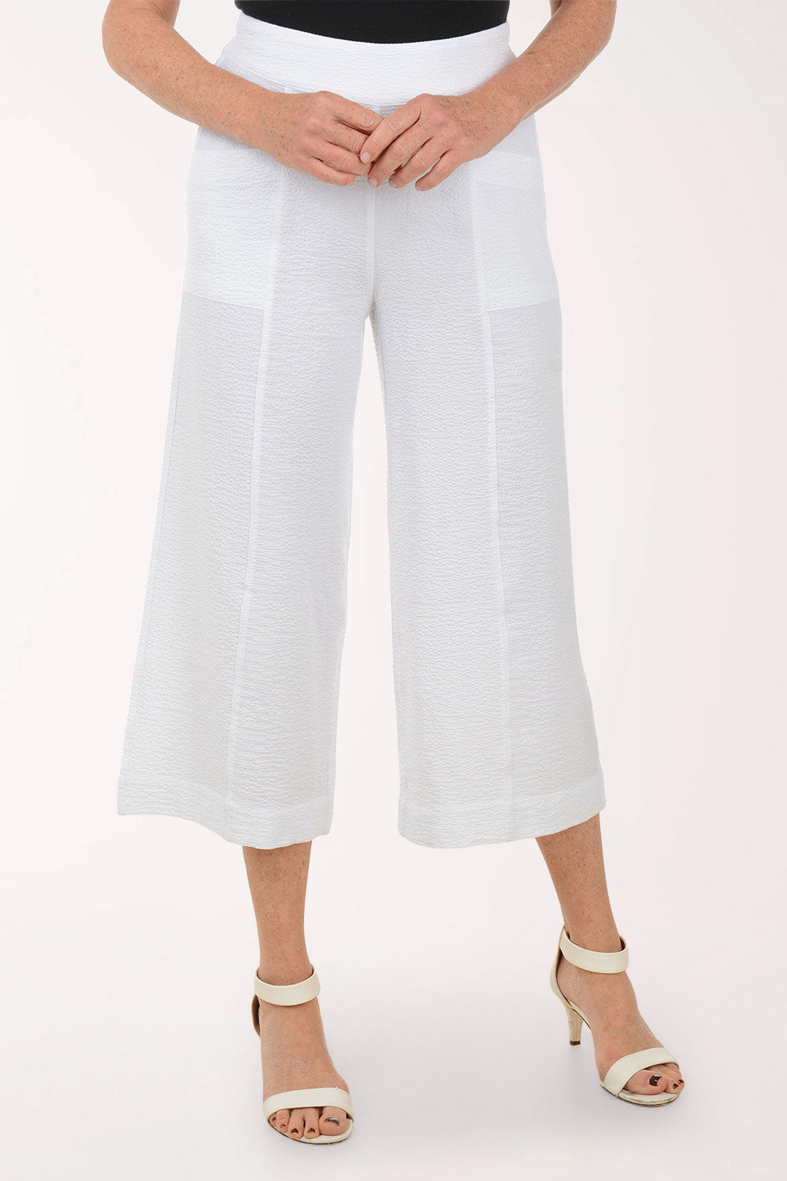 White wide-leg pants worn by a person on a white background