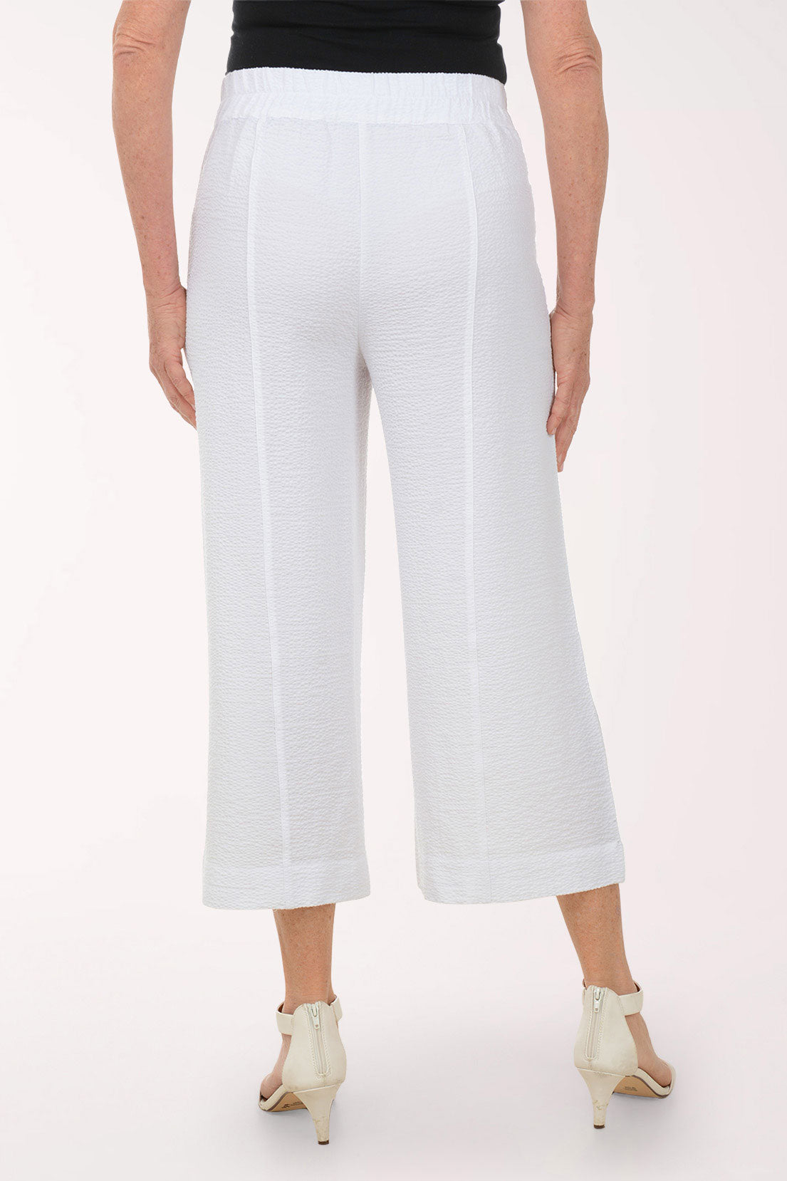White wide-leg pants worn by a person on a white background