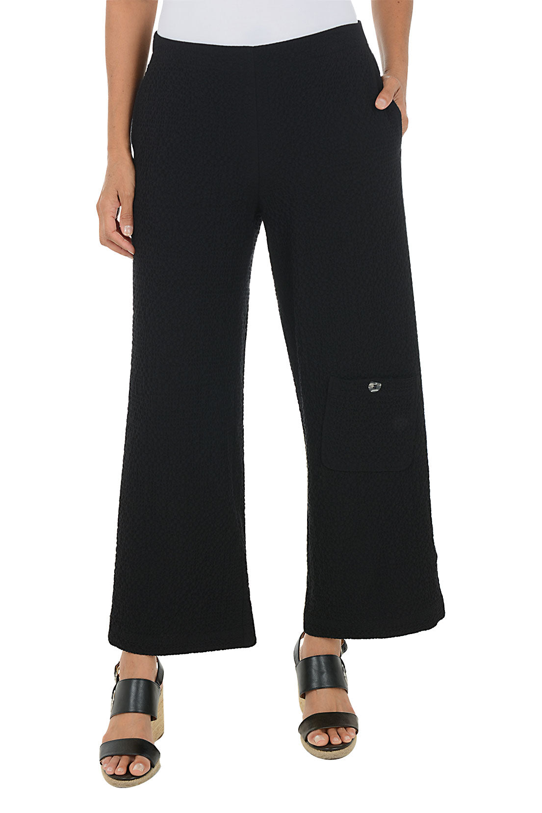 Person wearing black wide-leg pants on a white background.