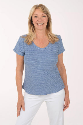 Woman wearing a blue striped shirt and white pants on a white background
