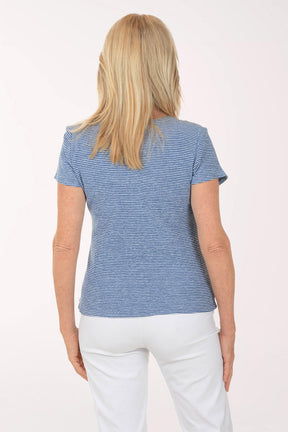 Woman wearing a blue striped shirt and white pants on a white background