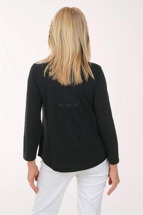 Woman wearing a black cardigan and white pants on a white background