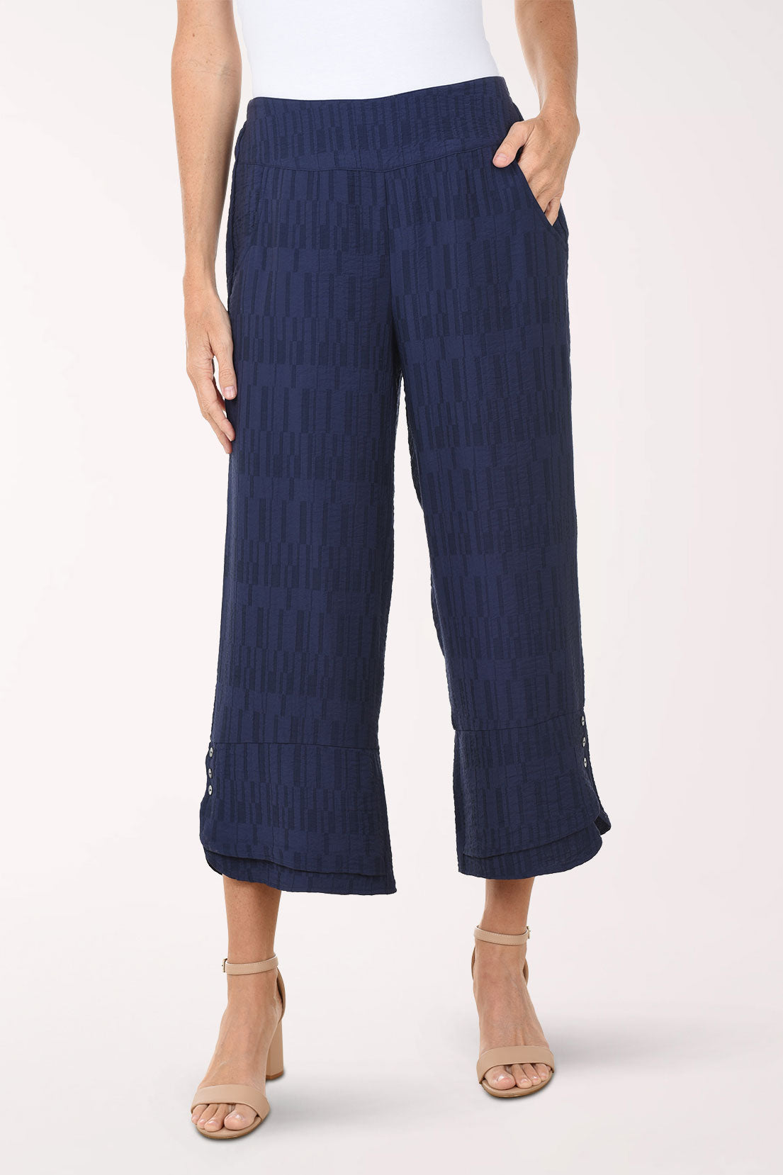 Navy blue textured pants worn by a person on a white background