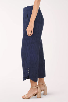 Navy blue textured pants worn by a person on a white background