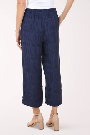 Navy blue textured pants worn by a person on a white background