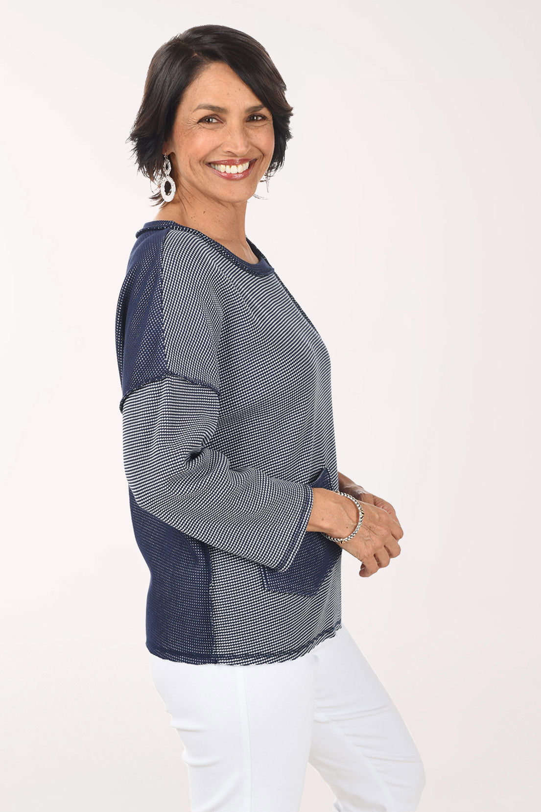 Woman wearing a blue and white striped shirt with a pocket on a white background
