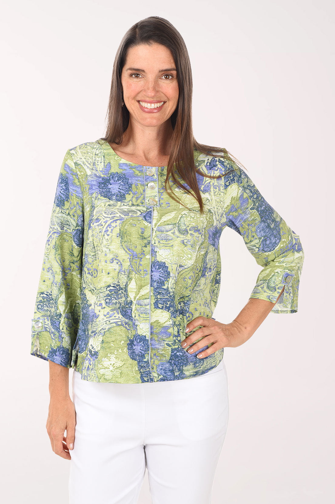 Woman wearing a green and blue patterned blouse on a white background