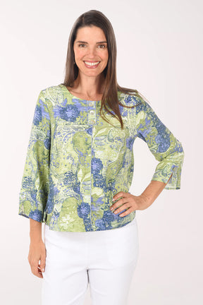 Woman wearing a green and blue patterned blouse on a white background