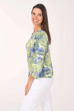 Woman wearing a green and blue patterned blouse on a white background