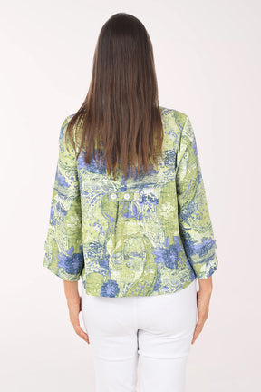 Woman wearing a green and blue patterned blouse on a white background