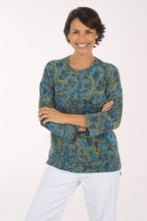 Woman wearing a blue multi colored paisley knit top with 3/4 sleeves